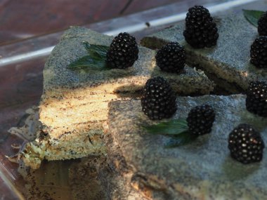 Ev yapımı haşhaş tohumu ile doldurulmuş un ve böğürtlenlerle süslenmiş kek.