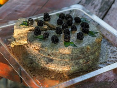 Ev yapımı haşhaş tohumu ile doldurulmuş un ve böğürtlenlerle süslenmiş kek.