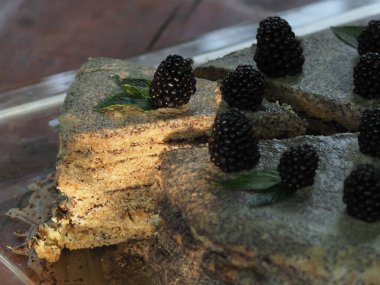 Ev yapımı haşhaş tohumu ile doldurulmuş un ve böğürtlenlerle süslenmiş kek.