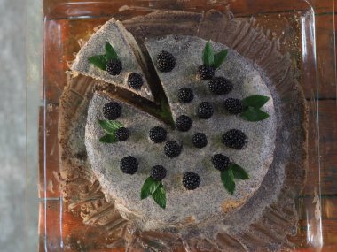 Ev yapımı haşhaş tohumu ile doldurulmuş un ve böğürtlenlerle süslenmiş kek.