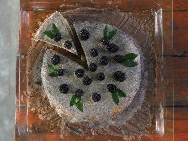 Ev yapımı haşhaş tohumu ile doldurulmuş un ve böğürtlenlerle süslenmiş kek.