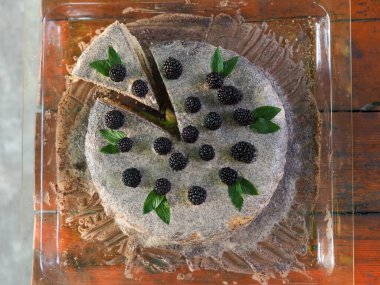 Ev yapımı haşhaş tohumu ile doldurulmuş un ve böğürtlenlerle süslenmiş kek.