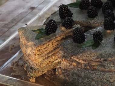 Ev yapımı haşhaş tohumu ile doldurulmuş un ve böğürtlenlerle süslenmiş kek.