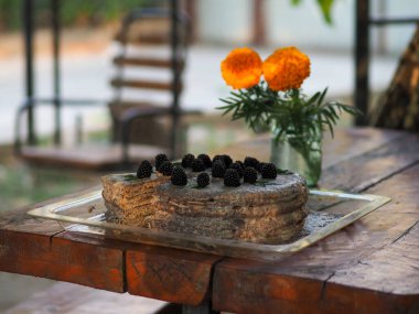 Ev yapımı haşhaş tohumu ile doldurulmuş un ve böğürtlenlerle süslenmiş kek.