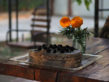 Ev yapımı haşhaş tohumu ile doldurulmuş un ve böğürtlenlerle süslenmiş kek.