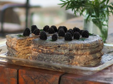 Ev yapımı haşhaş tohumu ile doldurulmuş un ve böğürtlenlerle süslenmiş kek.