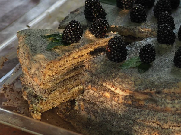 Ev yapımı haşhaş tohumu ile doldurulmuş un ve böğürtlenlerle süslenmiş kek.