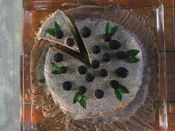 Ev yapımı haşhaş tohumu ile doldurulmuş un ve böğürtlenlerle süslenmiş kek.