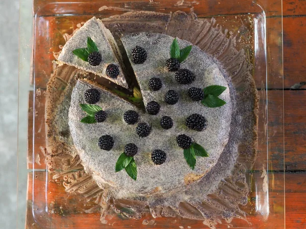 Ev yapımı haşhaş tohumu ile doldurulmuş un ve böğürtlenlerle süslenmiş kek.