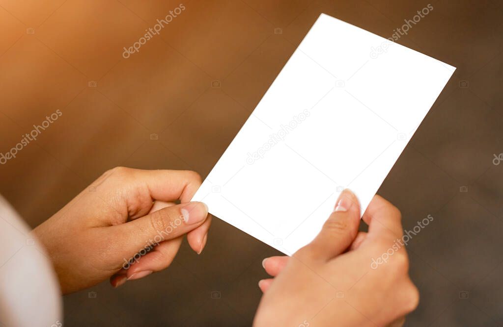 A person holding a white blank paper in her hand warm 