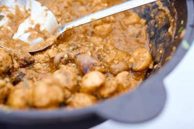 Kepçeli demir bir kazanda etli haşlanmış patates.