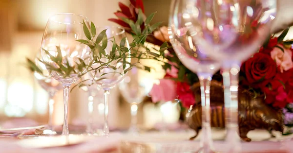 Vinné sklenice na stole zdobené barevnými květy a zeleným brunchem — Stock fotografie
