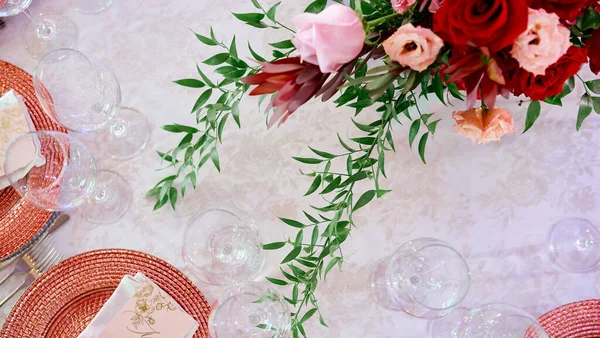 Çiçeklerle süslenmiş tabak karınca bardaklarıyla servis edilen masa. — Stok fotoğraf