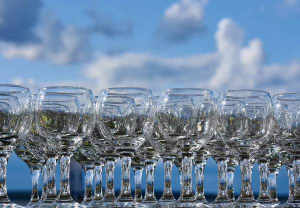 Много пустых бокалов вина и коктейлей на фоне неба — стоковое фото