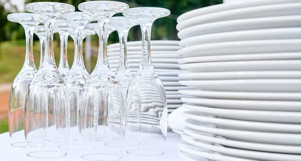 Cateringové služby. detailní záběr brýle bez vína a talíře pozadí na venkovní párty. — Stock fotografie