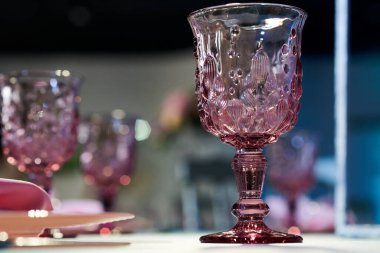 Cam bir fincanın yakın plan resmi. Masadaki pembe asma camı.