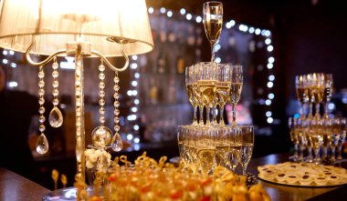 Masa lambası sütyenli şarap kadehi piramidi olan bir masa.