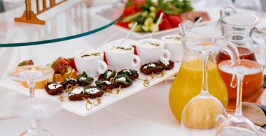 Yemek servisi. Kurutulmuş et, bir fincan sos ve sandviç. Meyve suyu ve bardakla.