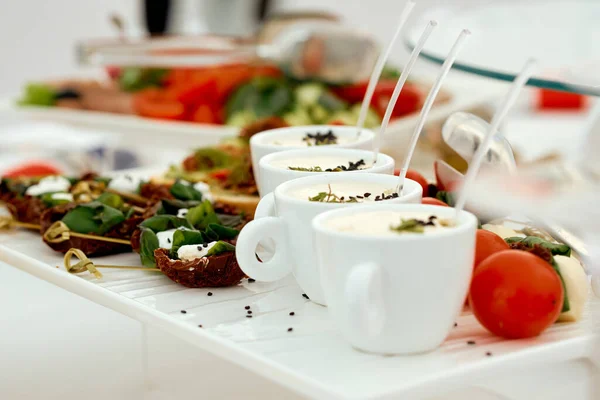 Catering. Canapé de carne seca, xícaras de molho e tomate pequeno — Fotografia de Stock