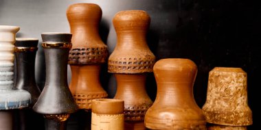 Kara duvarın yanında birkaç kil nargile bardağı var.