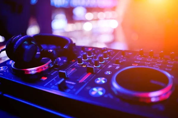 DJ remote controller in nightclub in perspective with professional headphones