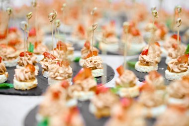 Bir sürü kanepe siyah tepsilerde beyaz bir masada.