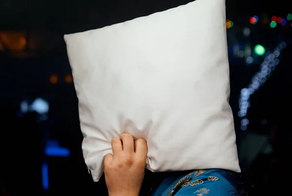 back view of man hiding face with pillow in club party