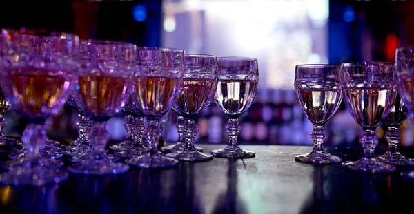 Viele mit Getränken gefüllte Weingläser mit einem leeren Sitz — Stockfoto