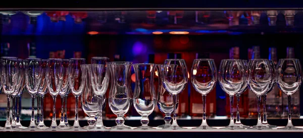 Barevná řada prázdných sklenic na víno na polici v baru — Stock fotografie