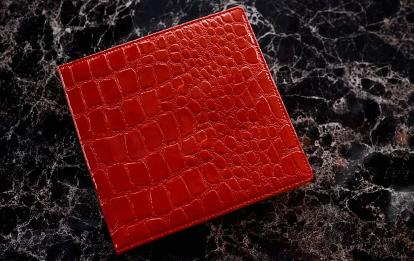 folder, red leather cover with a large texture on a gray marble table