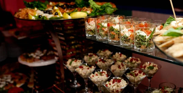 Catering. Óculos com saladas e lanches em prateleiras de vidro . — Fotografia de Stock