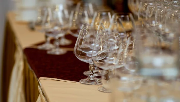 Много бокалов вина на краю стола на скатертях золото с бархатом — стоковое фото