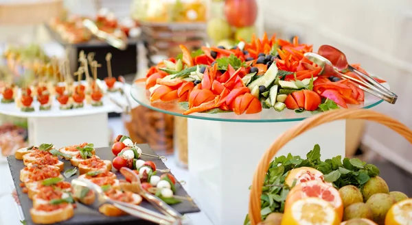 A covered self-service table organized catering with fruit vegetables and sandwiches — Stock Photo, Image
