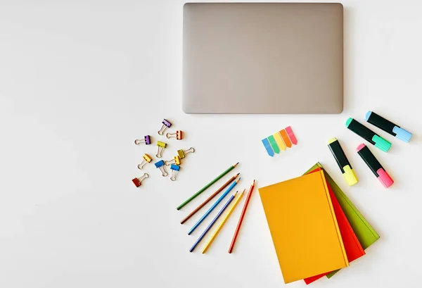 En el escritorio blanco hay un ordenador portátil y papelería — Foto de Stock