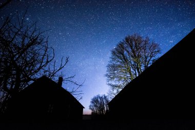 Eski binaların üzerinde yıldızlı gökyüzü