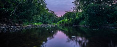 Dağların arasında taşlar akan bir dağ nehri. Uzun pozlama. 