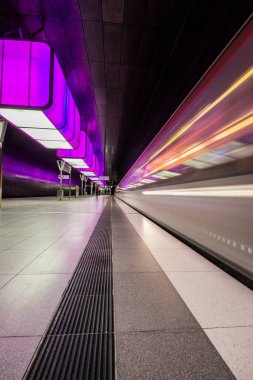 Hamburg, Almanya - 11 Temmuz 2018: Metro İstasyonu'na Speicherstadt alanda Hamburg Üniversitesi'nde mor ışıklı. Tren bulanıklık olduğunu.