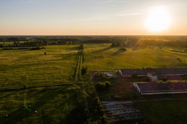 Terk edilmiş çiftlik evi / ahır havadan görünümü. İnanılmaz yaz manzarası. Günbatımı. 