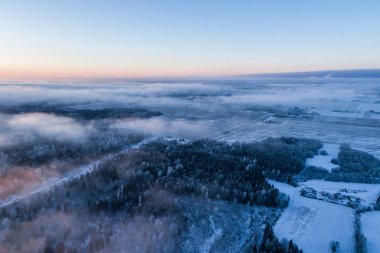 Gün batımında ormanın üzerindeki bulutların havadan görünümü. İnanılmaz kış manzarası.