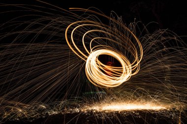 Adam iplik yanan çelik yün havadan görünümü. İplik çelik yün parlayan kıvılcımlar duş. Drone görünümü. 