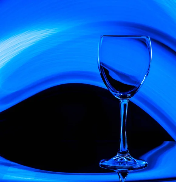 Copo de vinho em um fundo preto com cor azul — Fotografia de Stock