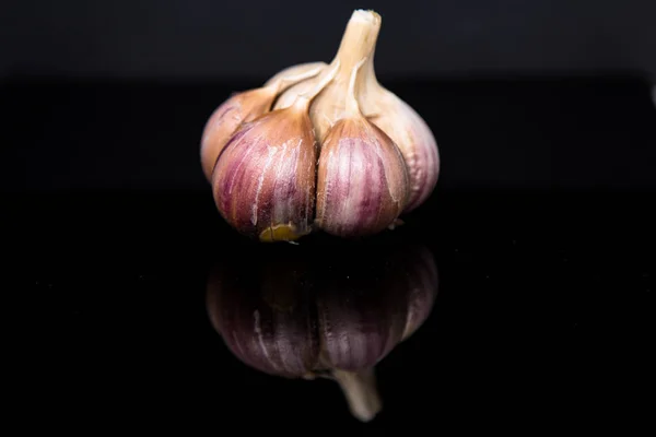 The picture shows garlic on black glass.