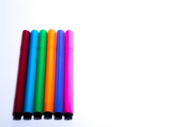 fotoğraf, beyaz bir arka planda çizim yapmak için farklı renklerin belirteçlerinin bir kümesini gösterir