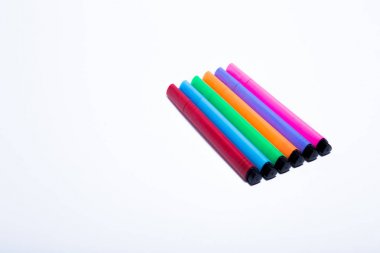 fotoğraf, beyaz bir arka planda çizim yapmak için farklı renklerin belirteçlerinin bir kümesini gösterir