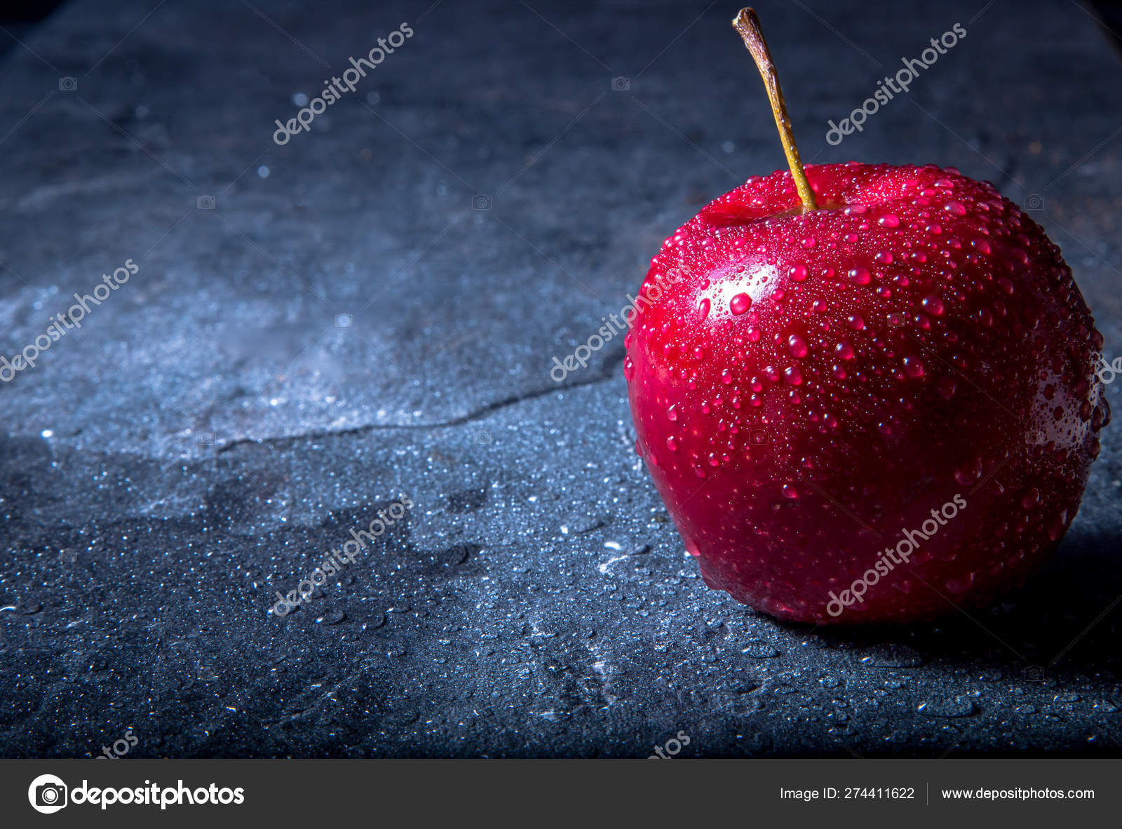 一个湿的红色的多汁的苹果躺在大理石酒吧柜台上暗背景 图库照片 C Vikasorokina