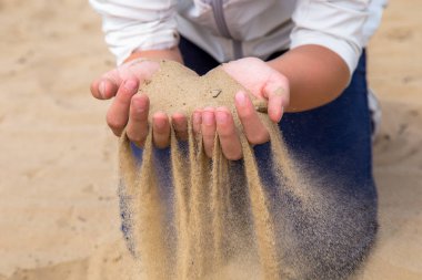 Eller kumu serbest bırakın. Kum ellerinden akar. Yaz plaj tatili