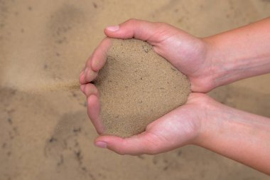 Eller kumu serbest bırakın. Kum ellerinden akar. Yaz plaj tatili