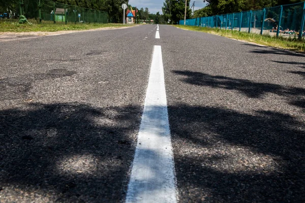 Road marking on asphalt. Painted signs on the roadway for drivers of various vehicles. Dotted line and arrows. Belarus