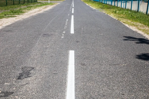 Road marking on asphalt. Painted signs on the roadway for drivers of various vehicles. Dotted line and arrows. Belarus