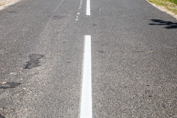 Road marking on asphalt. Painted signs on the roadway for drivers of various vehicles. Dotted line and arrows. Belarus